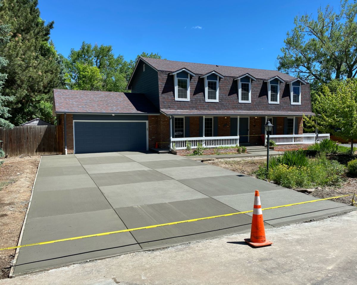New concrete driveway poured by Denver Concrete Company in front of a brick home in Denver